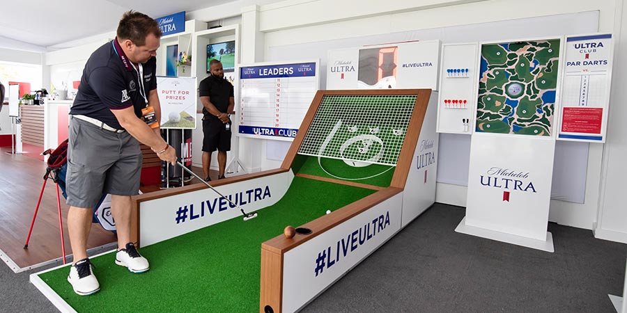 Man playing mini golf game in sponsor tent